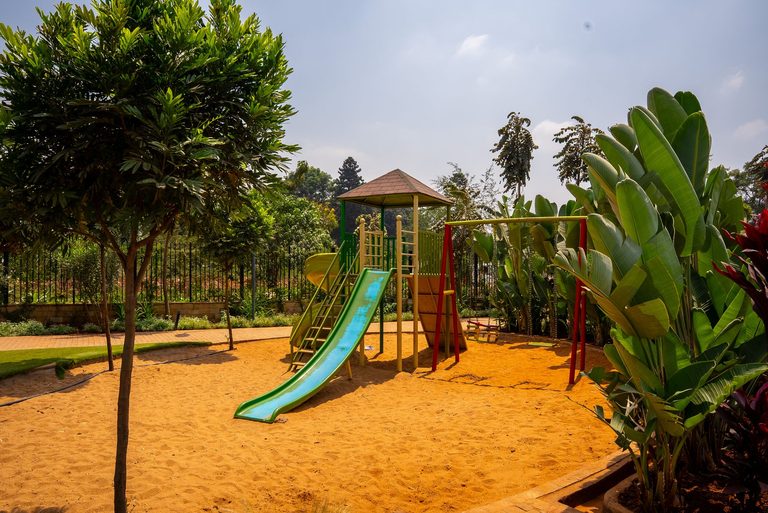 playground with a slide set in a sand area, Garden City