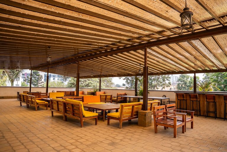 rooftop lounge tables and benches under a pergola roof, Garden City