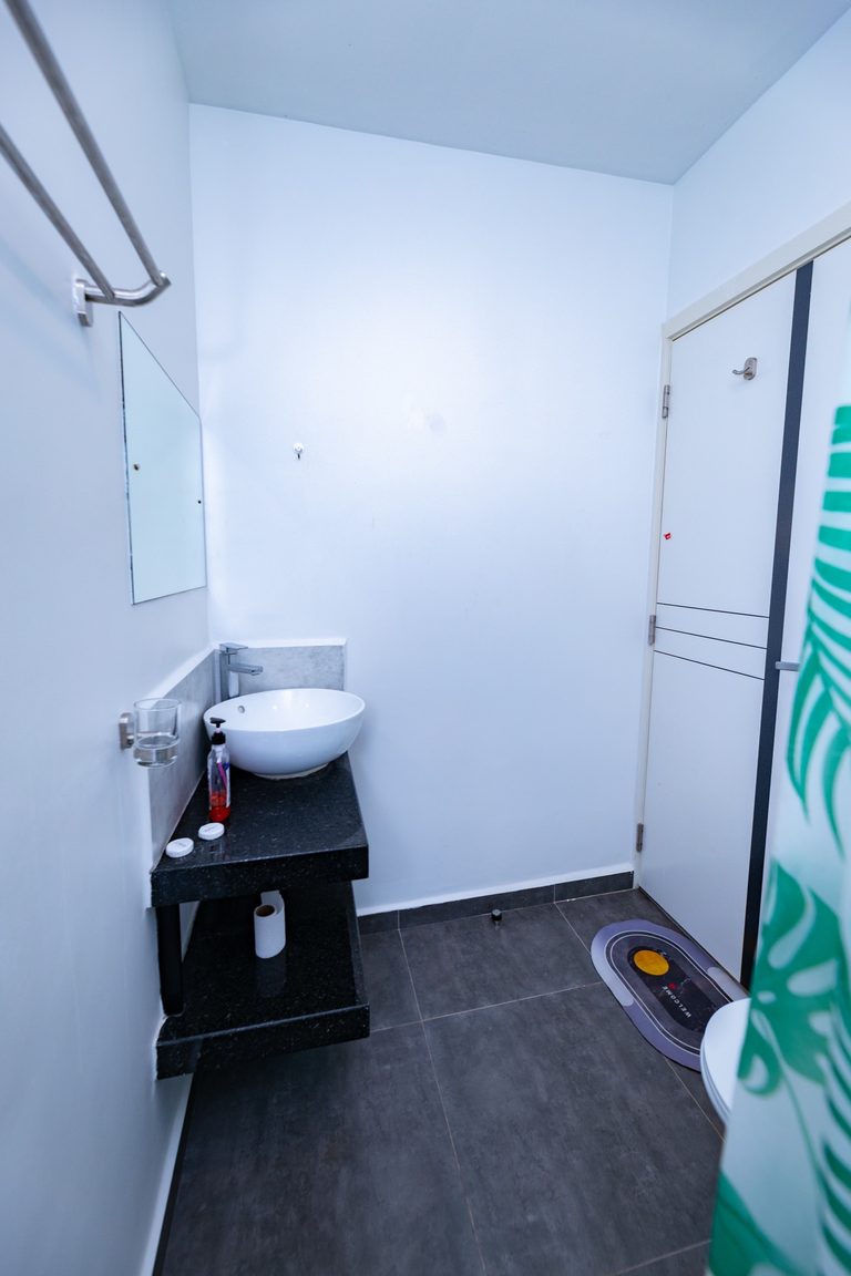 Vessel sink near the shower door, with a welcome mat and shower curtain, The Bloom, Tatu City