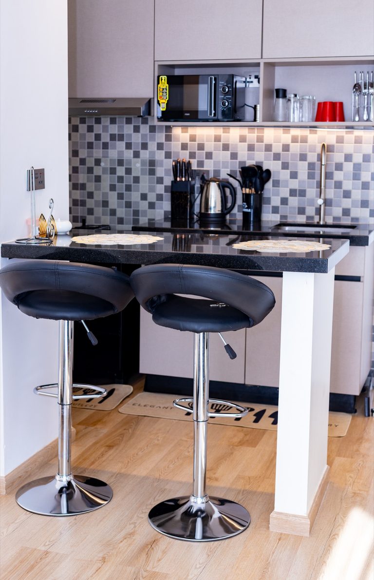 Kitchen counter and mosaic backsplash with two black barstools, The Canopy, Tatu City