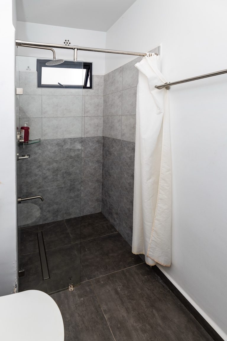 Walk in shower stall with grey tile and a shower curtain, The Deco, Tatu City