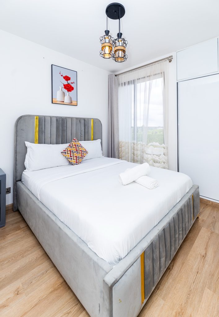 Grey channel tufted bed with a colourful patterned cushion, wide view, The Deco, Tatu City