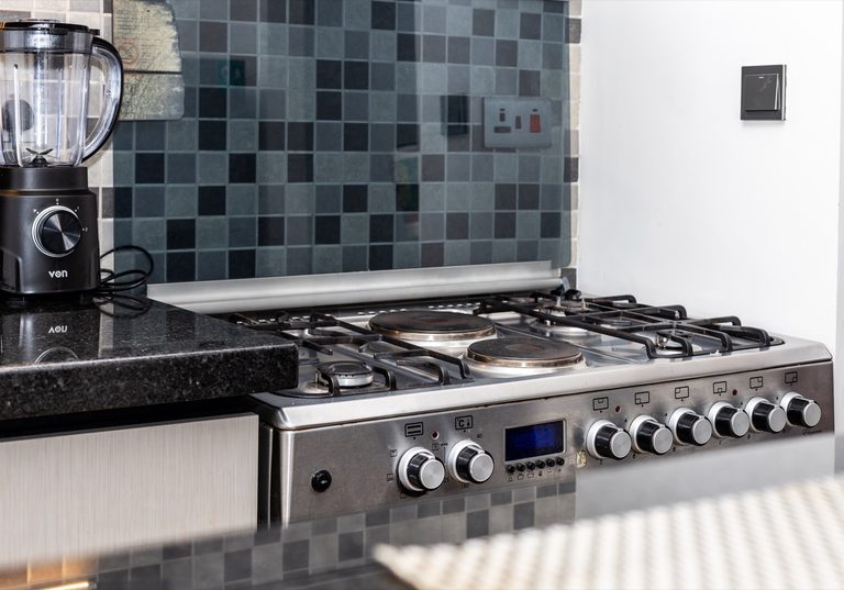 Blender and gas stove burners against tiled backsplash, The Deco, Tatu City
