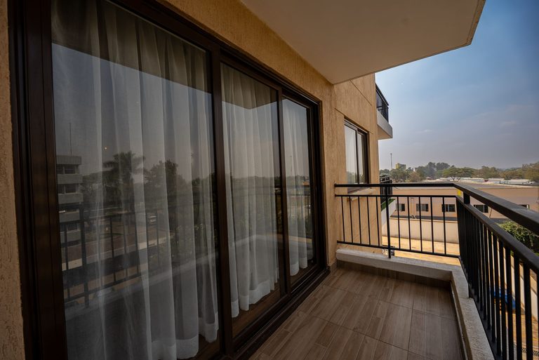 balcony sliding door with a sheer curtain and railing, The Emerald, Garden City