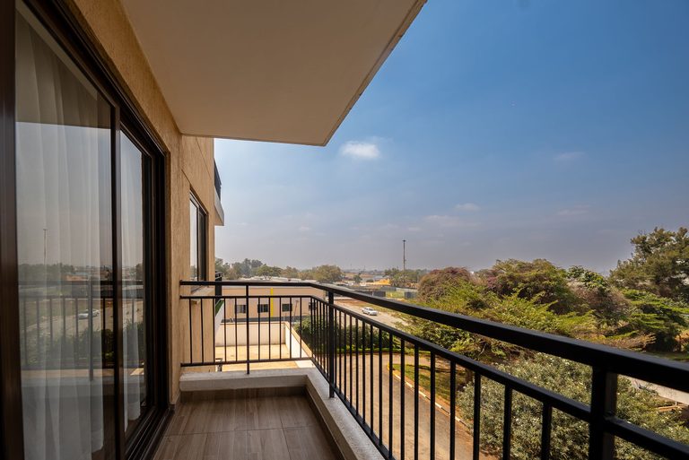 balcony with a metal railing looking out over trees, The Emerald, Garden City