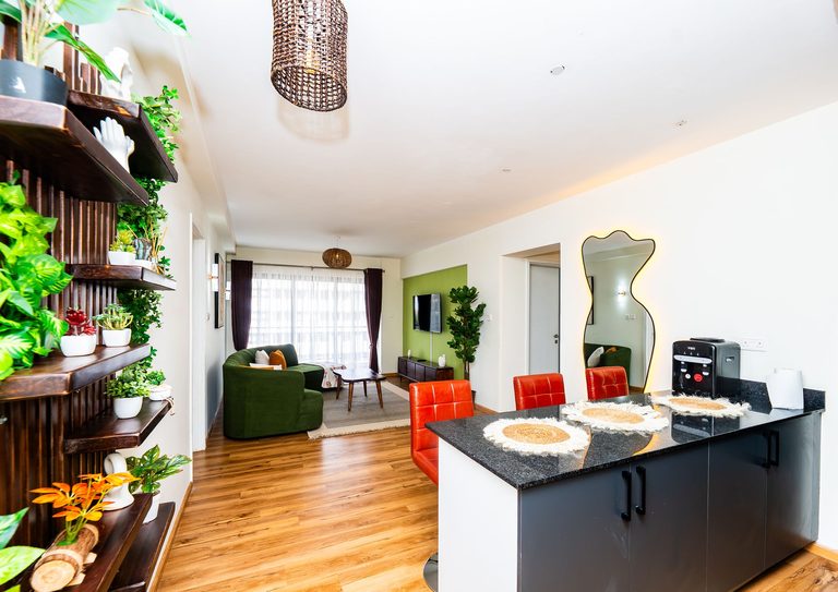 open plan living and dining space with a mirror and red chairs, The Emerald, Garden City