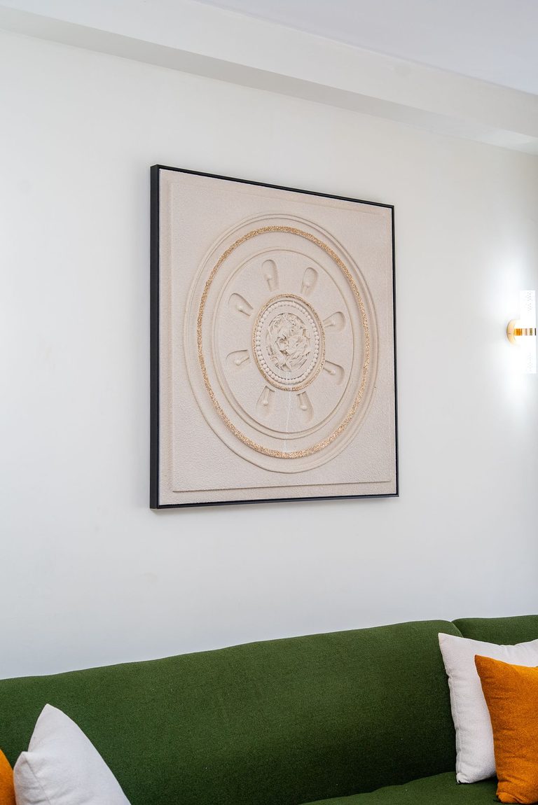 round wall art hanging above the green sofa, The Emerald, Garden City