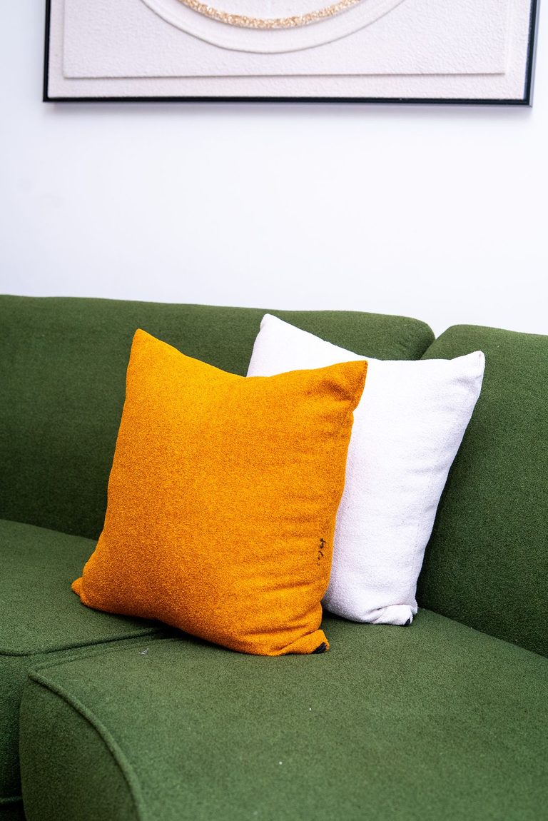 cushions on the green sofa with wall art in the background, The Emerald, Garden City