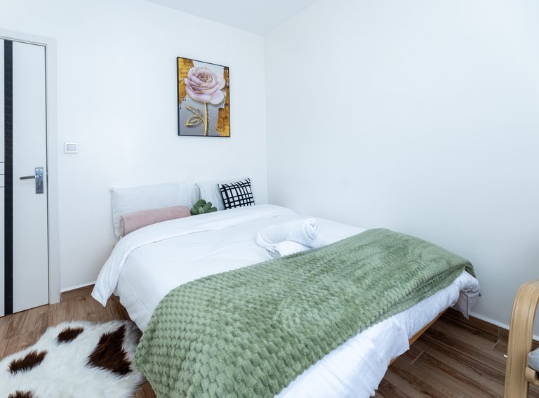 Main bedroom king bed with rose artwork above it and a cowhide rug, The Gallery, Tatu City