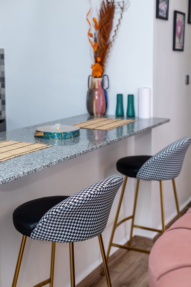 Granite breakfast bar with two houndstooth barstools and a dried flower vase, The Gallery, Tatu City
