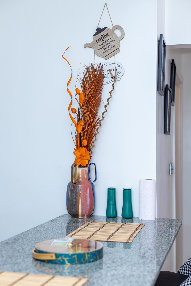 Close-up of a dried flower arrangement and green glass bottles on the kitchen counter, The Gallery, Tatu City