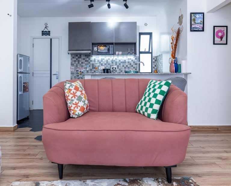 Dusty rose velvet loveseat with a green checkered cushion, The Gallery, Tatu City