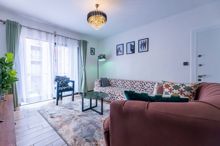 Living room with sheer curtains at the glass door and the patterned sofa, The Gallery, Tatu City