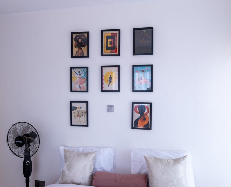 Second bedroom gallery wall of framed art above the bed pillows, The Gallery, Tatu City