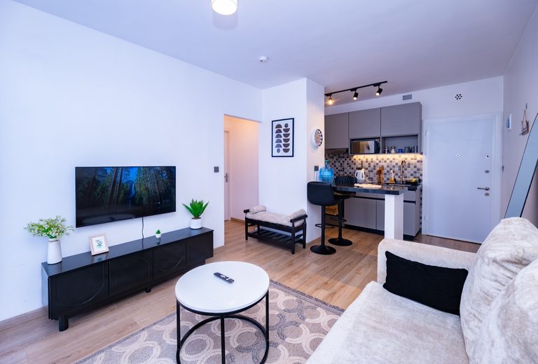 TV wall with a media console and the kitchen breakfast bar visible beyond, The Graphite, Tatu City