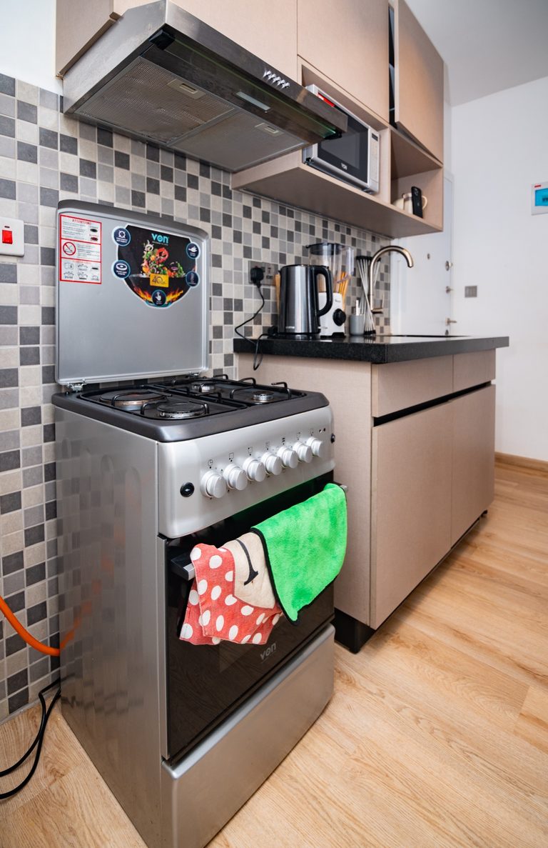 Gas stove close up against a checkered tile backsplash, The Hearth, Tatu City