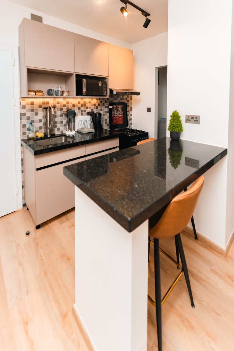Grey kitchen cabinets with tiled backsplash and a bar stool, The Hearth, Tatu City