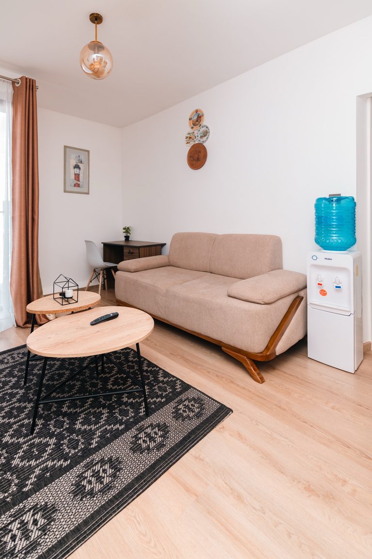 Sofa and coffee table under a wall clock and throw blanket, The Hearth, Tatu City