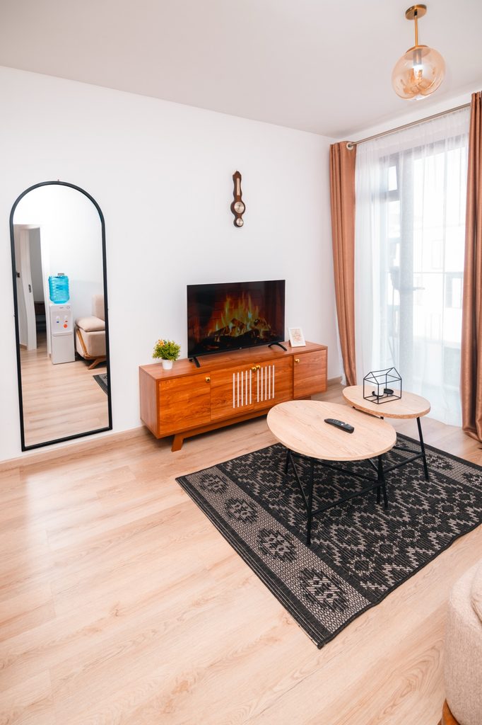 TV with fireplace display next to a tall mirror near the entryway, The Hearth, Tatu City