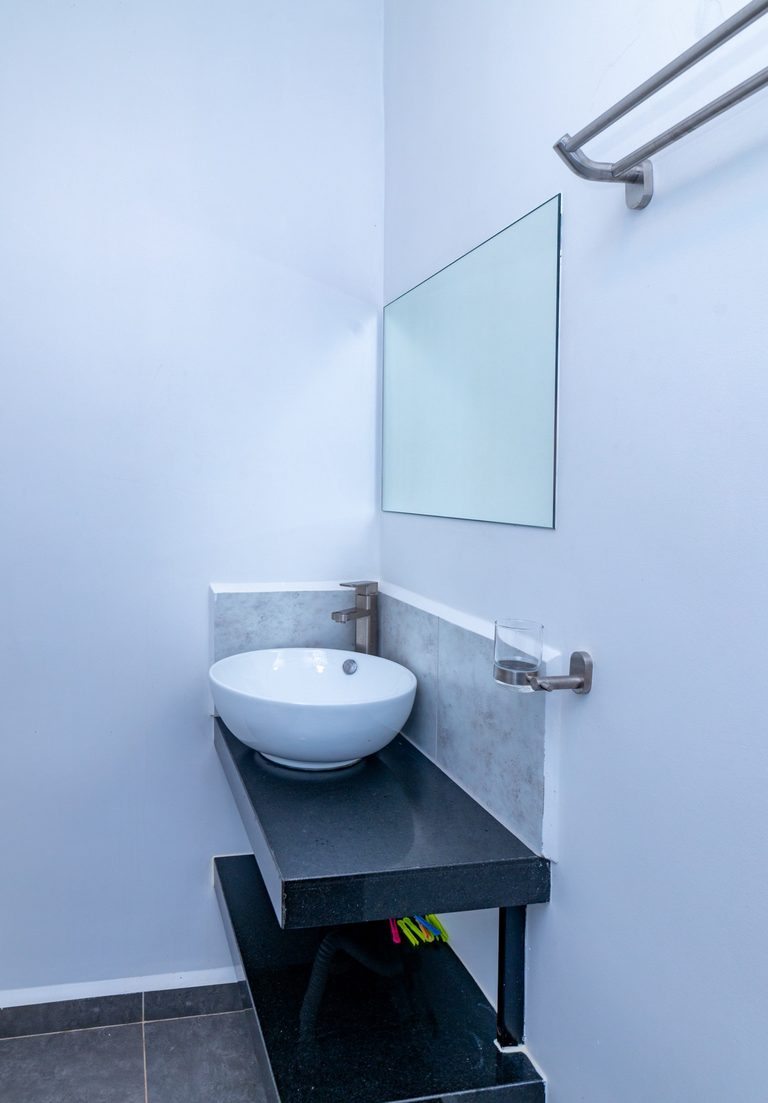 Small round vessel sink on a dark shelf below a mirror, The Metro, Tatu City