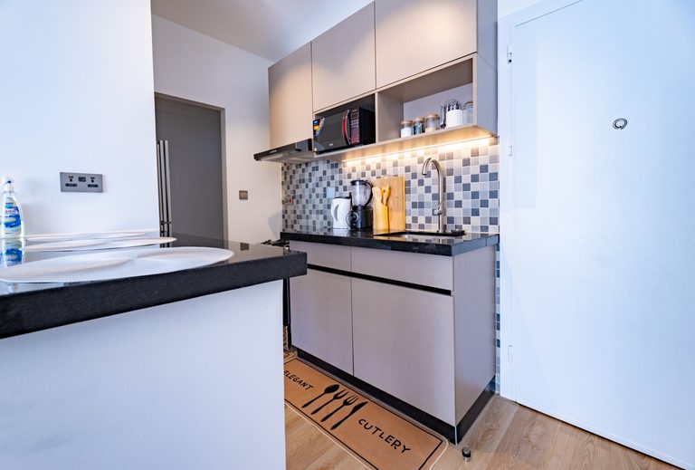 Kitchen counter with blender and kettle against a grey mosaic tile backsplash, The Metro, Tatu City
