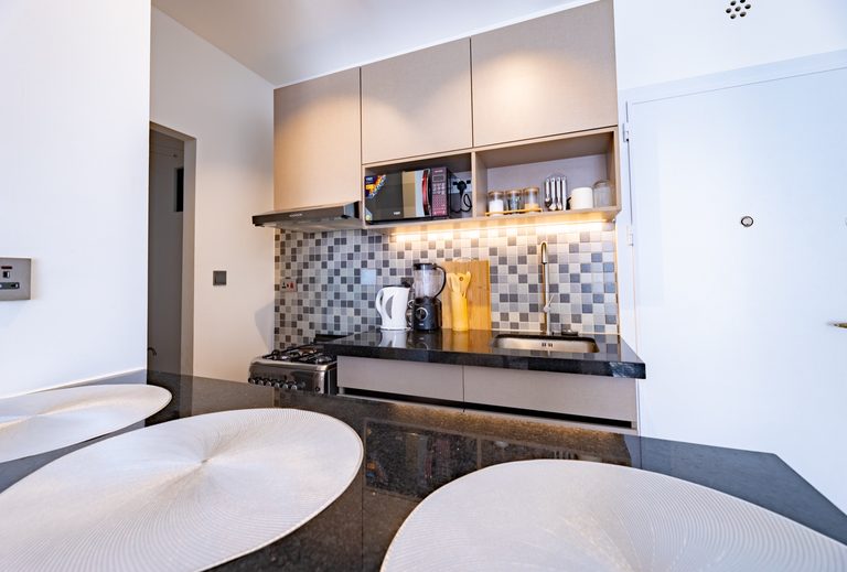 Kitchen area with a round dining table and two chairs in the foreground, The Metro, Tatu City