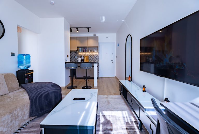 Sofa facing TV console with a water dispenser and hallway to kitchen, The Metro, Tatu City