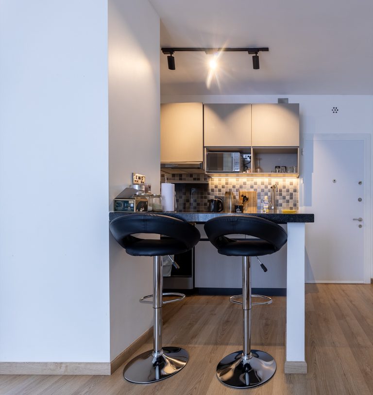 Kitchen breakfast bar with two black stools, upper cabinets and a microwave, The Tide, Tatu City