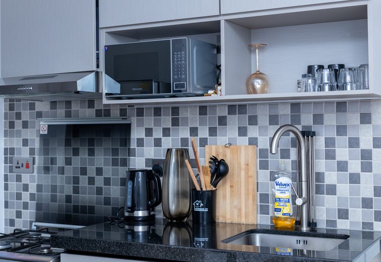 Close view of the kitchen counter with a kettle, utensil holder and sink, The Tide, Tatu City