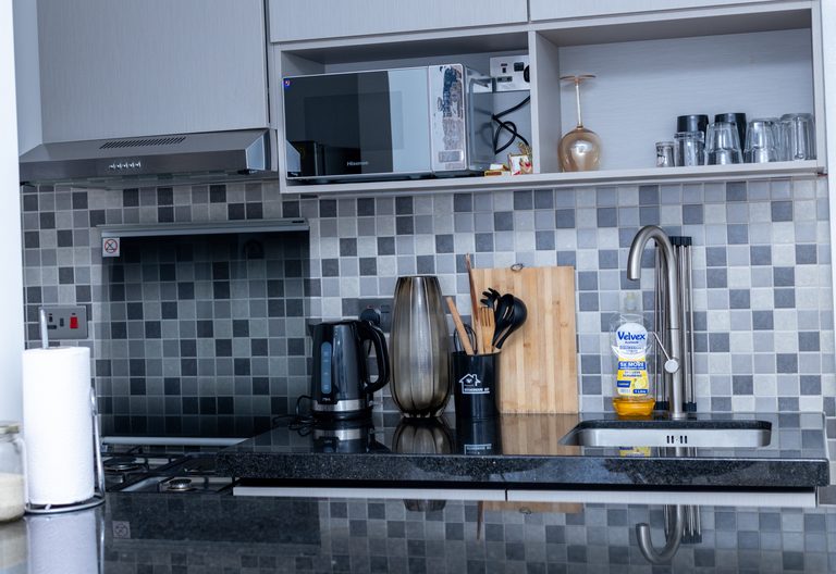 Upper kitchen cabinets with a built-in microwave and a shelf of glasses, The Tide, Tatu City