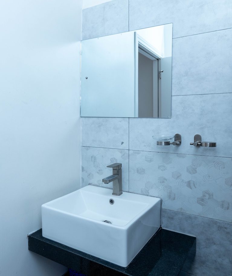 Bathroom with a floating black stone counter and a white square vessel sink, The Velvet, Tatu City