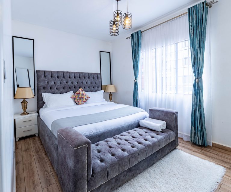 Main bedroom grey velvet bed with teal curtains, The Velvet, Tatu City