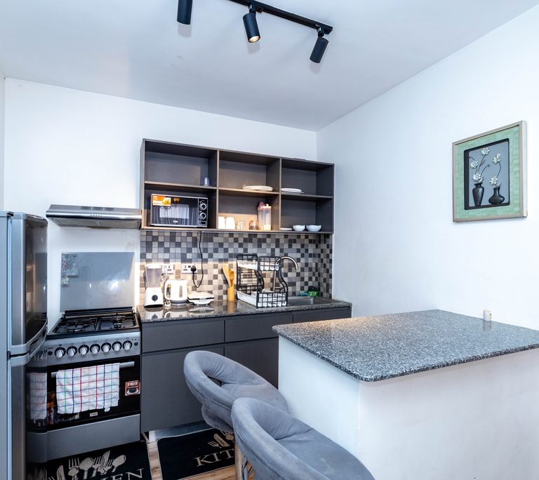 Kitchen breakfast bar with grey velvet swivel chairs and track lighting, The Velvet, Tatu City
